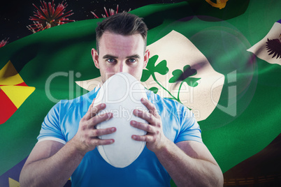 Composite image of rugby player looking at camera with ball