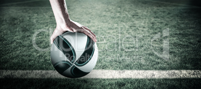 Composite image of rugby player with arm raised holding ball