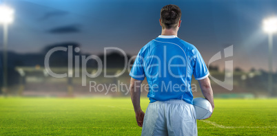 Composite image of rugby player holding a rugby ball