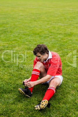 Rugby player tying his shoelace