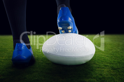 Composite image of rugby player posing feet on the ball