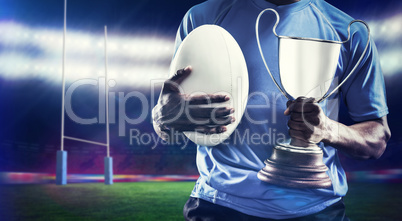 Composite image of mid section of sportsman holding trophy and r