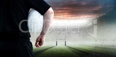 Composite image of rugby player holding a rugby ball