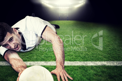 Composite image of man holding rugby ball while lying down