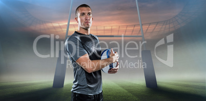 Composite image of confident rugby player in holding ball