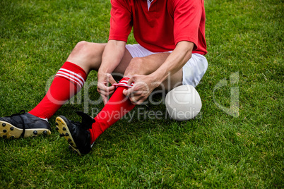 Rugby player sitting on grass