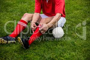 Rugby player sitting on grass