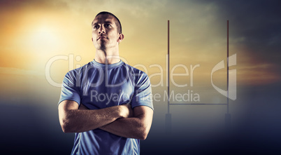 Composite image of confident rugby player looking away with arms