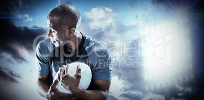 Composite image of rugby player looking away while catching ball