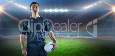 Composite image of rugby player holding a rugby ball