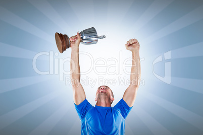 Composite image of happy rugby player holding trophy