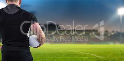 Composite image of rugby player holding the ball