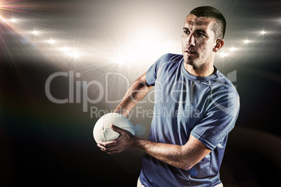 Composite image of rugby player looking away while holding ball Composite image of rugby player looking away while holding ball