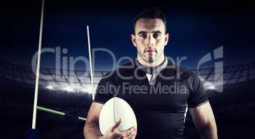 Composite image of tough rugby player holding ball