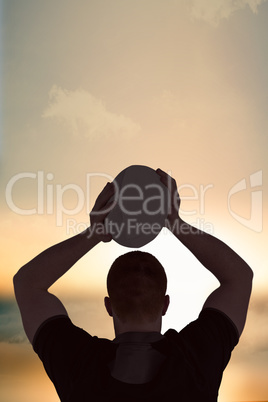 Composite image of rugby player about to throw a rugby ball