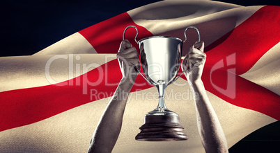 Composite image of successful rugby player holding trophy