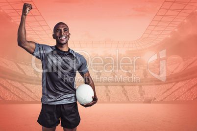 Composite image of happy sportsman with clenched fist holding ru