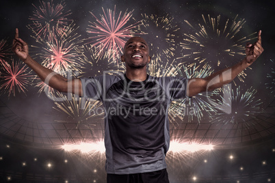 Composite image of happy sportsman with arms raised after victor