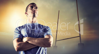 Composite image of serious rugby player looking away with arms c