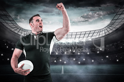 Composite image of rugby player cheering with the ball