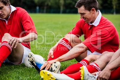 Rugby players sitting on grass before match