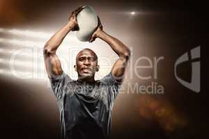 Composite image of determined sportsman throwing rugby ball