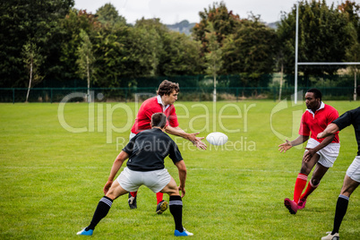 Rugby players passing during game