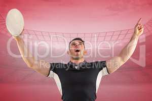 Composite image of rugby player cheering with the ball