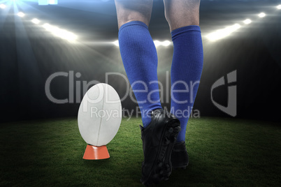Composite image of low section of rugby player about to kick the