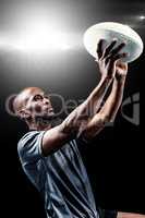 Composite image of rugby player looking up while throwing ball