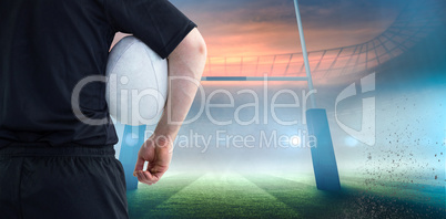 Composite image of rugby player holding a rugby ball