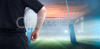 Composite image of rugby player holding a rugby ball