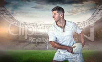 Composite image of rugby player holding the ball aside