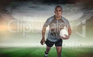 Composite image of portrait of determined sportsman holding rugb