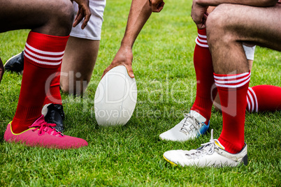 Rugby players in huddle with ball