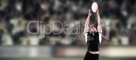 Composite image of rugby player catching the ball