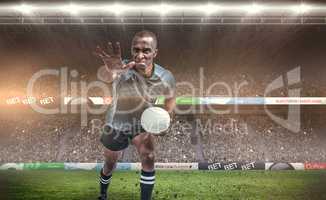 Composite image of aggressive rugby player gesturing while holdi