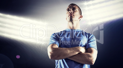 Composite image of serious rugby player looking away with arms c