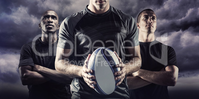 Composite image of thoughtful rugby player holding ball