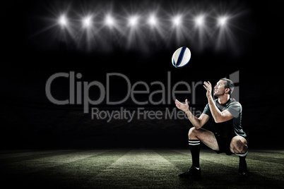 Composite image of full length of rugby player catching the ball