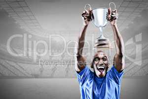 Composite image of happy athlete cheering while holding trophy