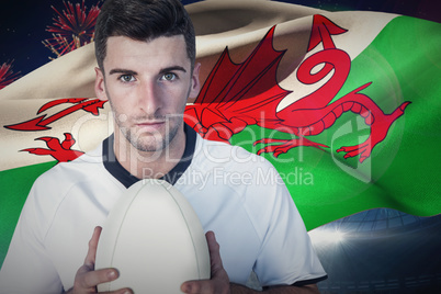 Composite image of portrait of a player holding rugby ball