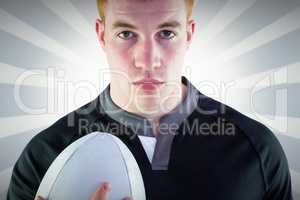 Composite image of rugby player holding a rugby ball