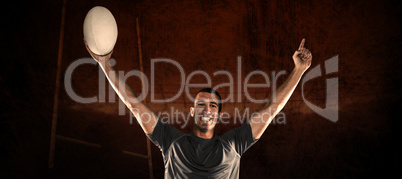 Composite image of portrait of rugby player in blue jersey holdi