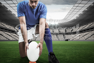 Composite image of full length of rugby player placing ball