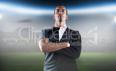 Composite image of confident rugby player with arms crossed