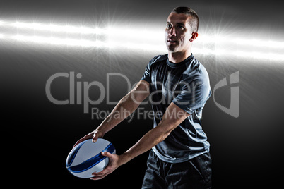 Composite image of focused rugby player looking away while holdi