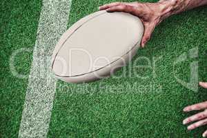 Composite image of cropped image of a man holding rugby ball