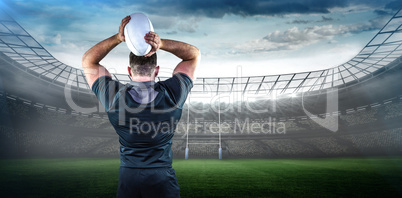 Composite image of tough rugby player throwing ball