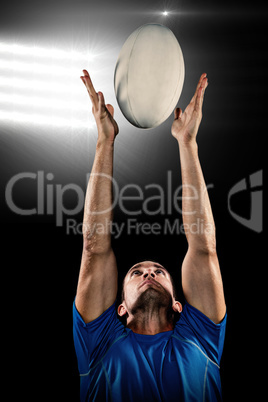 Composite image of rugby player catching ball